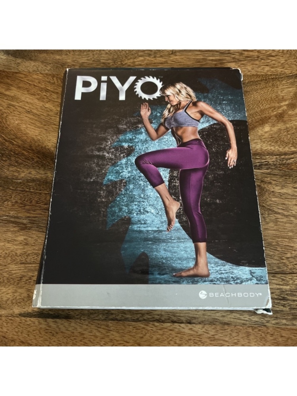 Beachbody PiYo Workout DVD with Purple Activewear and Gray Top